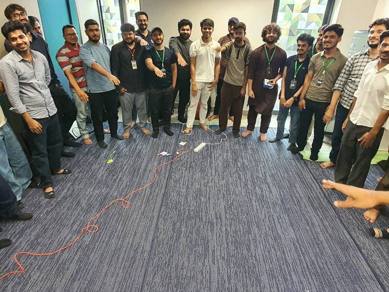 A circle of attendees pointing into the middle at Session 4