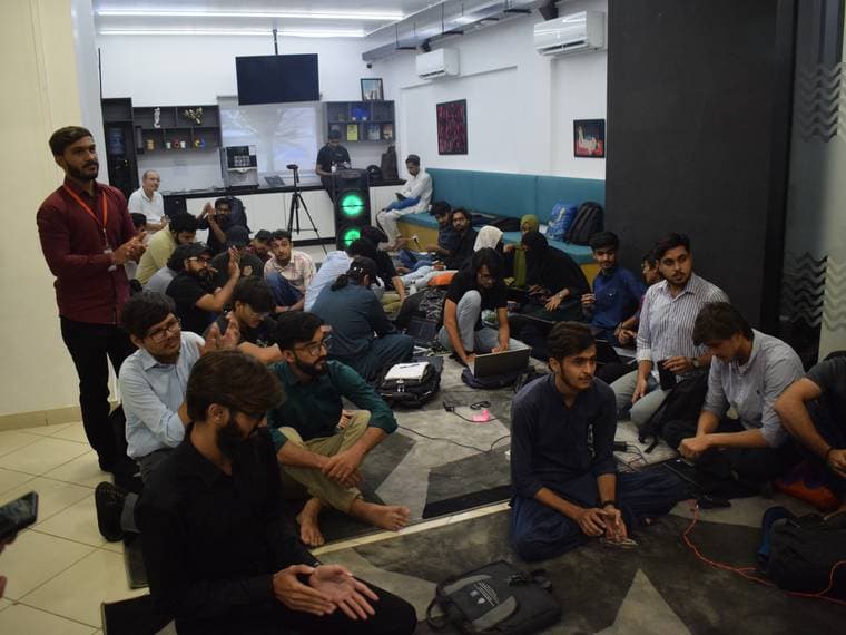 A packed room seated on the floor at Session 5