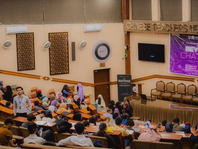A university lecture hall filling up for Session 6