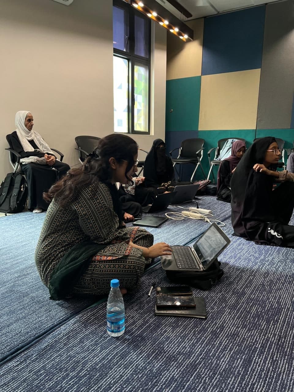 Two attendees working at laptops in a quieter corner during Session 4
