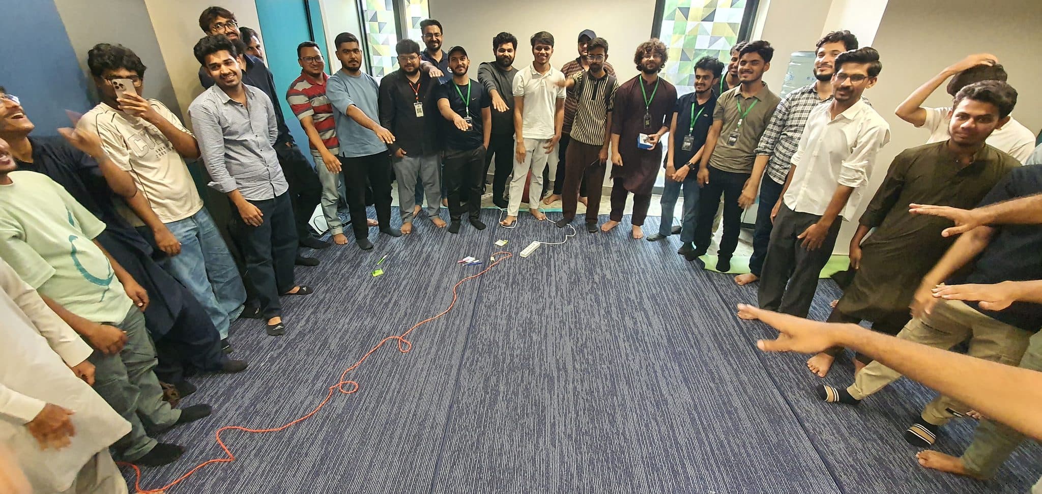 A circle of attendees pointing into the middle at Session 4